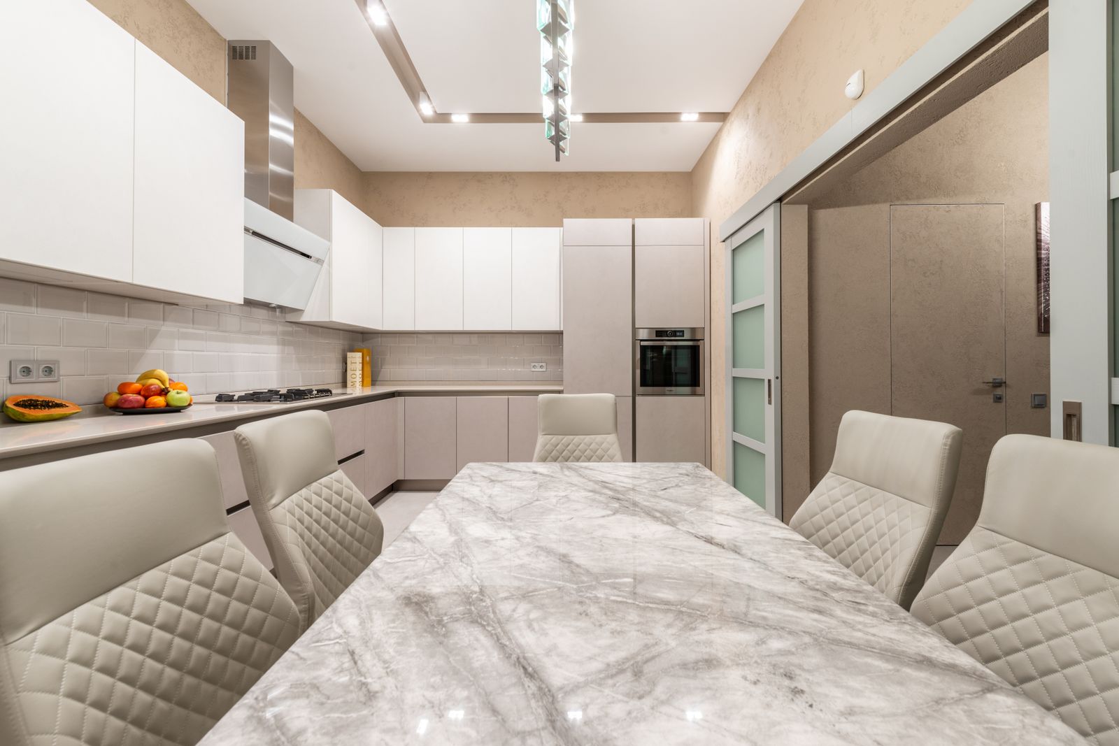 A contemporary open-plan kitchen with stainless appliances — Fisher & Paykel repair near you