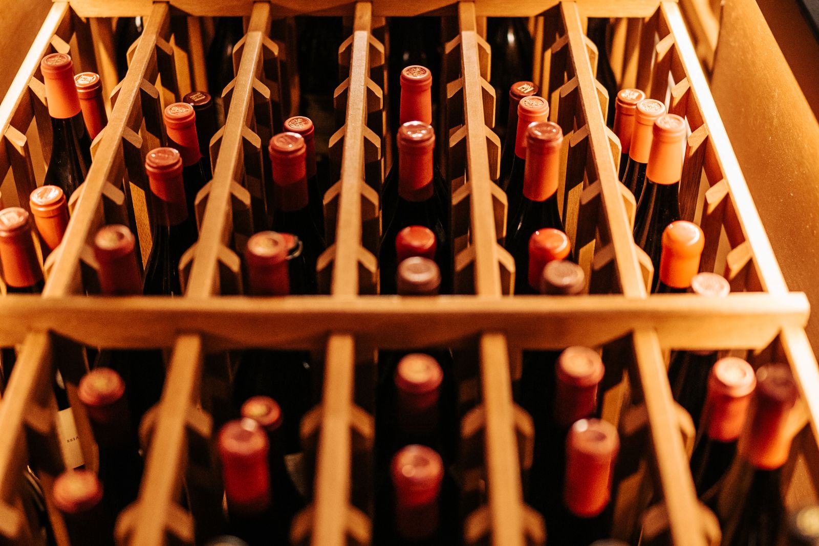 A built-in wine refrigerator stocked with bottles in a kitchen — Fisher & Paykel wine refrigerator repair